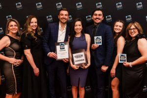 left to right: Aleta, Feather, Dr. Philip, Dr. Kat, Justin, Natalie and Melissa are standing in front of the Best of Reno background and red carpet